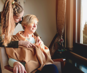 elderly woman and young woman looking out window