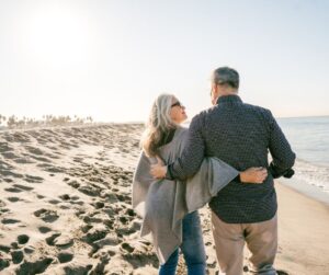 Two older people walking on the beach